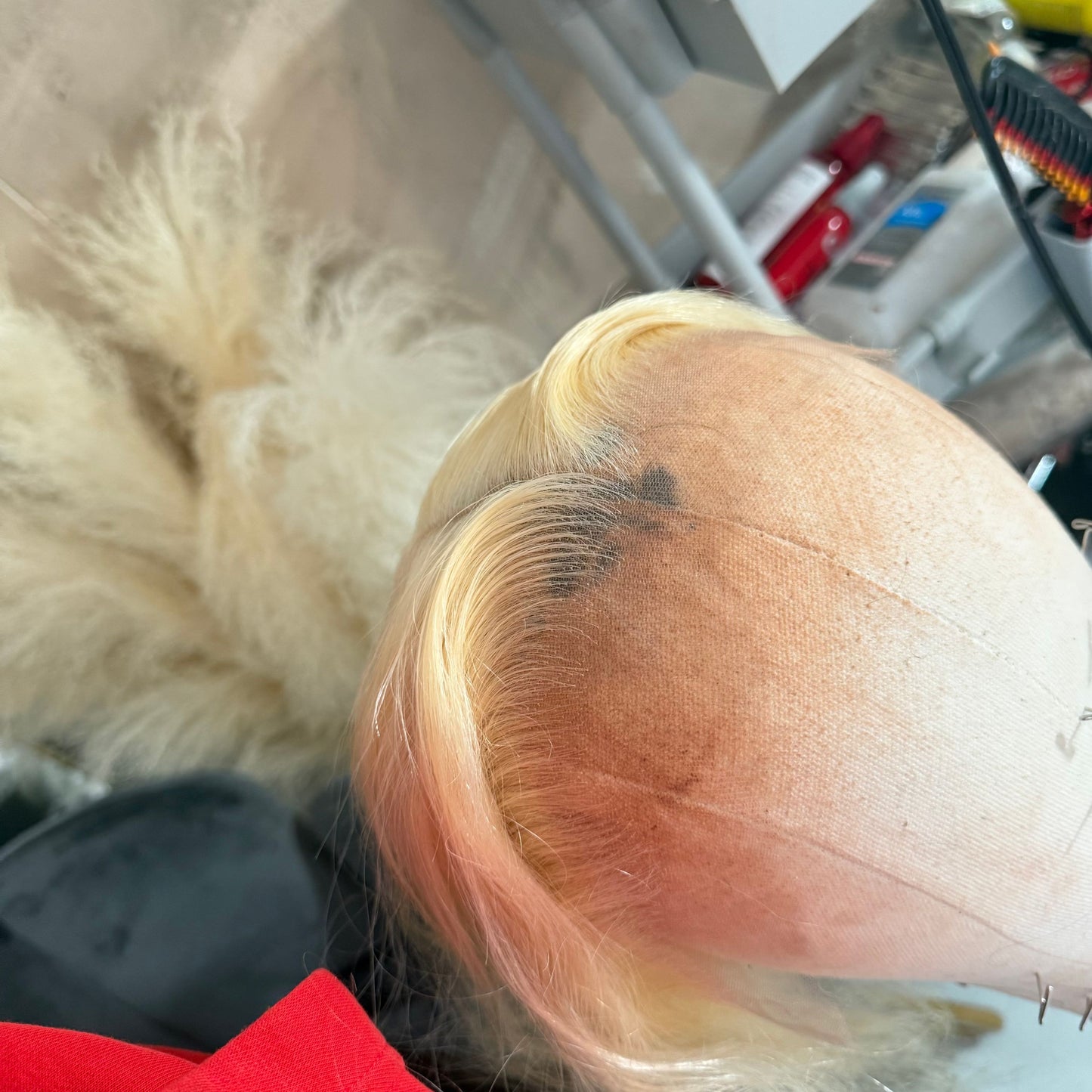 Close-up Detailed view of raw straight hair strands, thick and smooth of a blonde wig with a blurred background