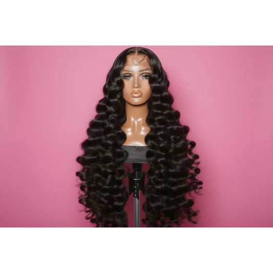 Black wig showcase in loose wave long curls on wic on a mannequin head against a pink background